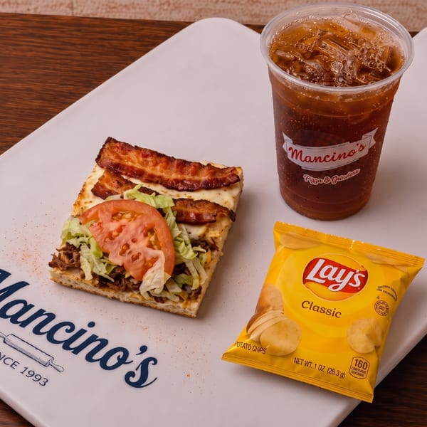 A cheesesteak combo with chips and a Mancino's drink.