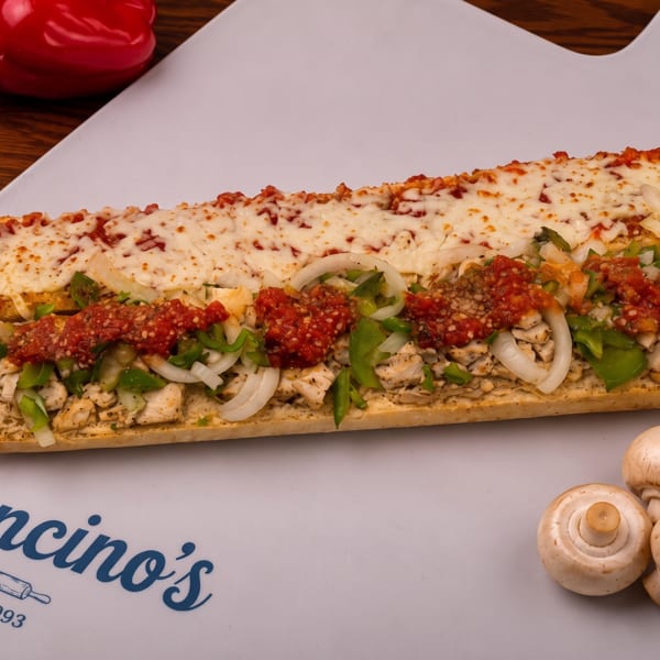 Chicken sub topped with melted cheese, peppers, onions, mushrooms, and tomato sauce on a Mancino’s plate.